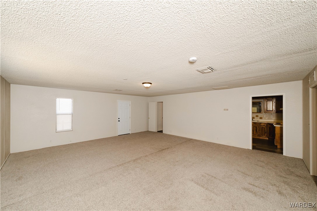 2063 East Sundown Road Kingman, AZ 86409 - Photo 28 of 40 Carpeted empty room featuring visible vents and a textured ceiling