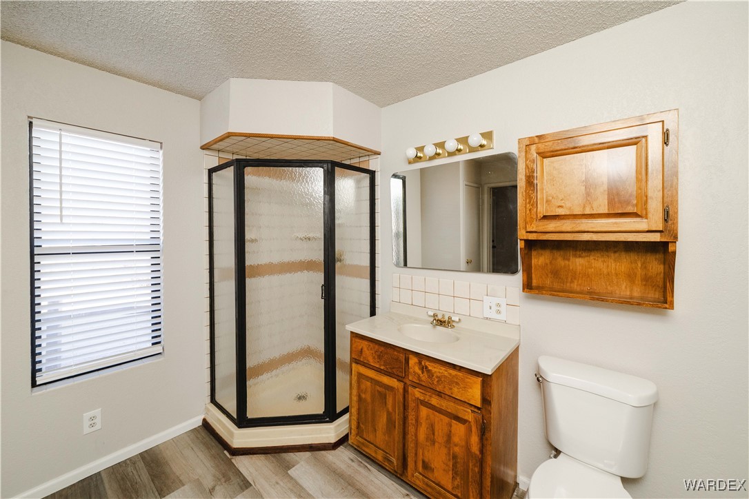 2063 East Sundown Road Kingman, AZ 86409 - Photo 29 of 40 3rd Bathroom with vanity, a textured ceiling, wood finished floors, and a shower stall