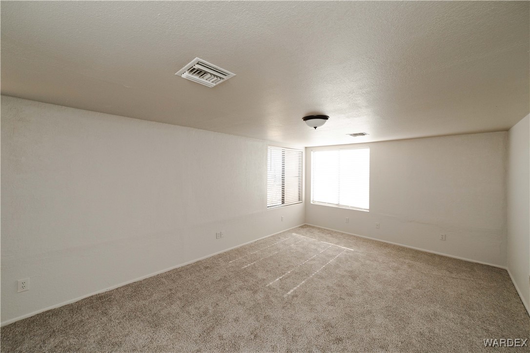 2063 East Sundown Road Kingman, AZ 86409 - Photo 32 of 40 Carpeted spare room featuring a textured ceiling and visible vents