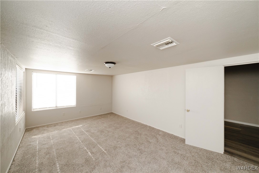 2063 East Sundown Road Kingman, AZ 86409 - Photo 33 of 40 Carpeted empty room featuring visible vents and a textured ceiling