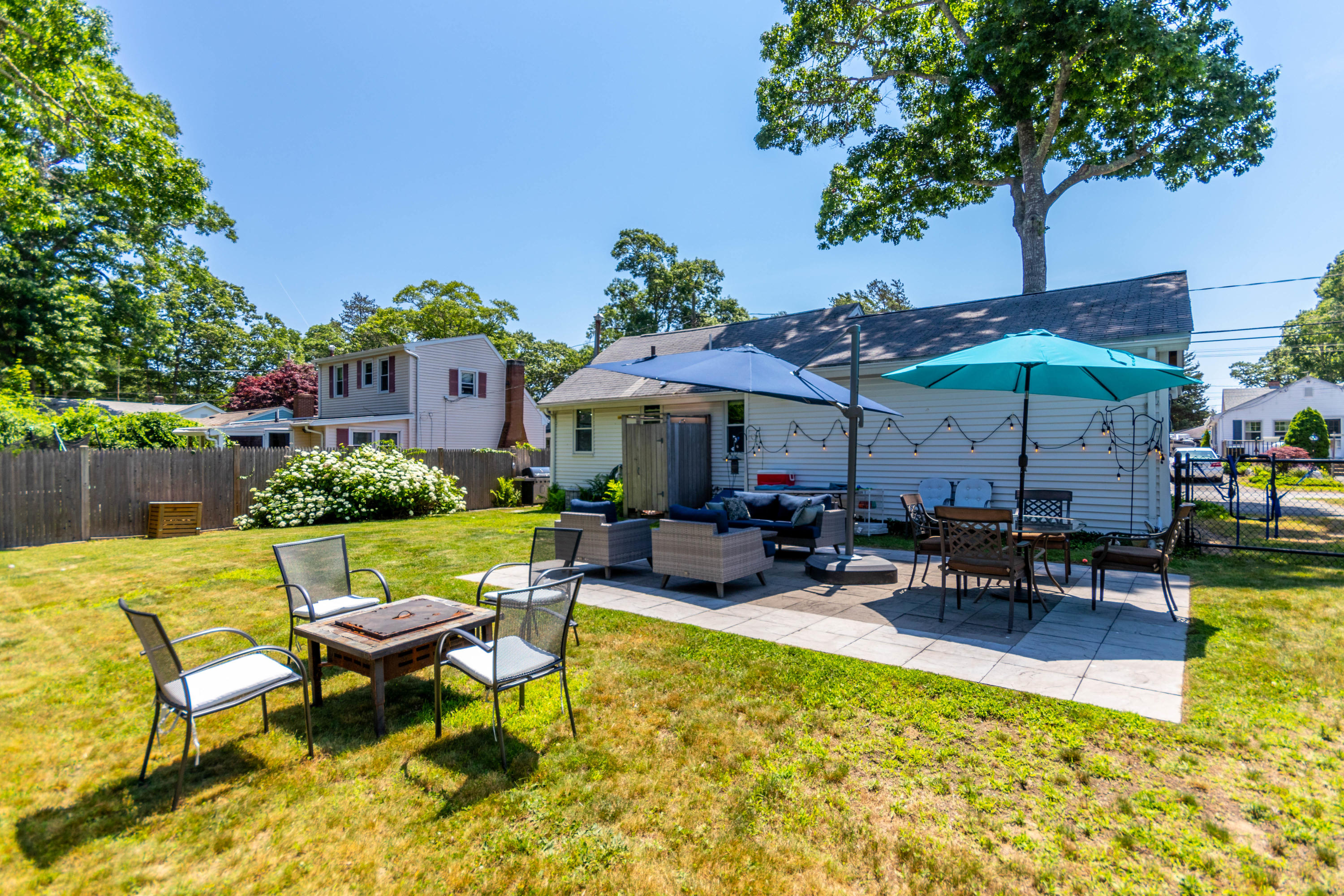 17 Ivy Street Wareham, MA 02571 - Photo 24 of 31 a view of a patio with table and chairs under an umbrella with a barbeque grill and plants