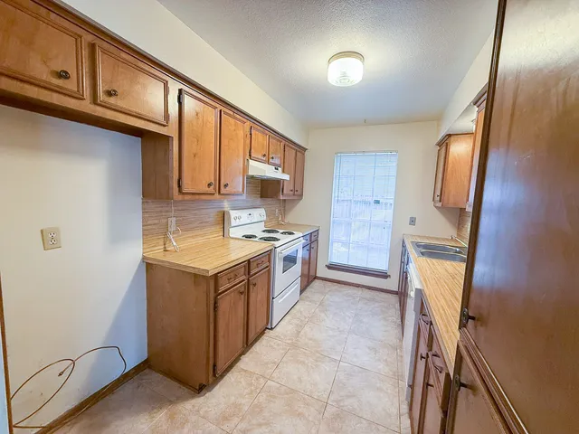 a kitchen with a refrigerator sink stove and cabinets