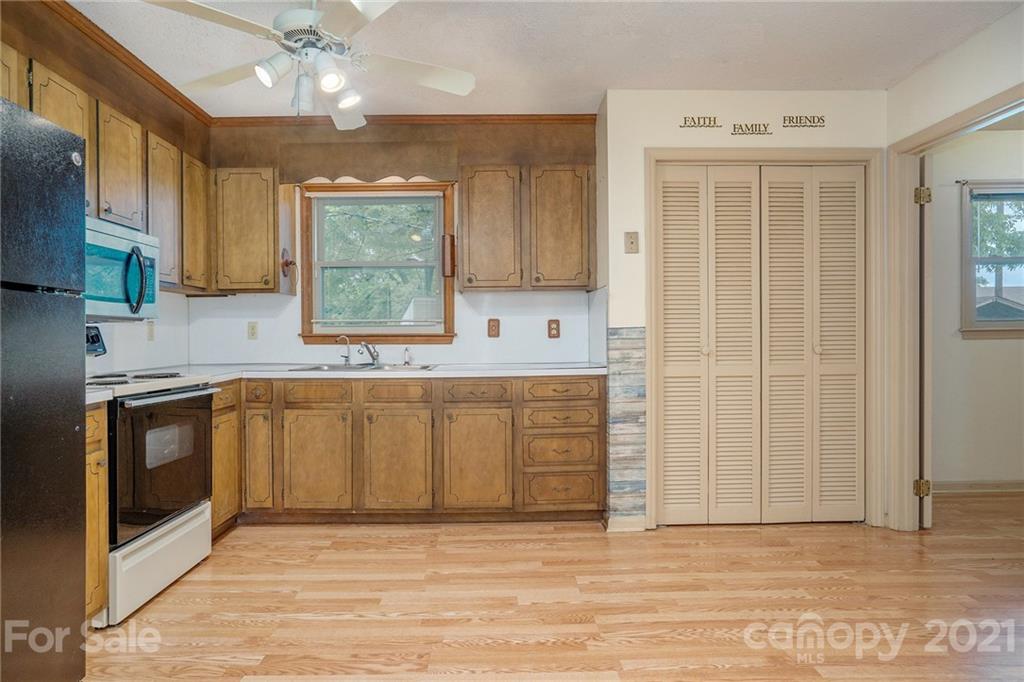 5661 Tuckaseegee Road Kannapolis, NC 28081 - Photo 6 of 18 a kitchen with stainless steel appliances granite countertop a sink cabinets and wooden floor