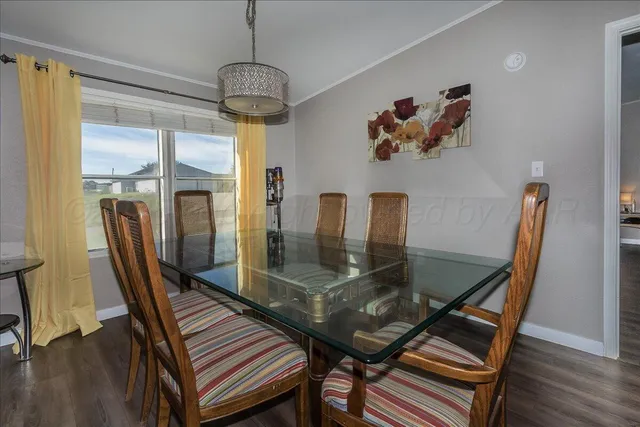a dining room with furniture a chandelier and wooden floor