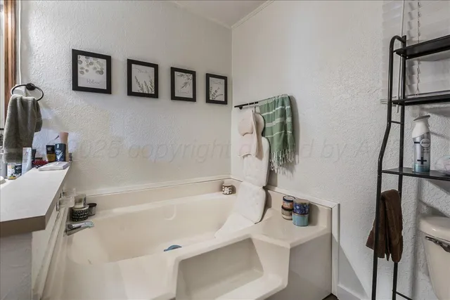 a bath tub sitting next to a white toilet and sink