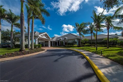 a view of a house with a yard and palm trees
