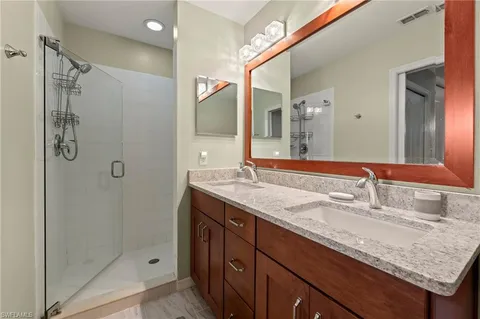 a bathroom with a granite countertop sink shower and a mirror