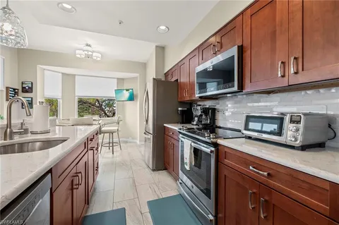 a kitchen with stainless steel appliances granite countertop a stove a sink and a microwave