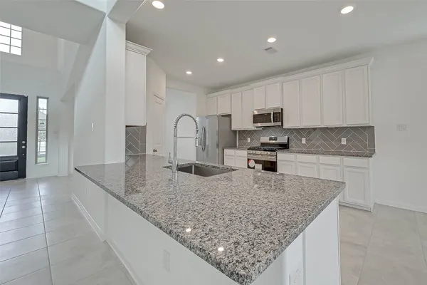 a bathroom with a granite countertop sink a mirror and a bathtub