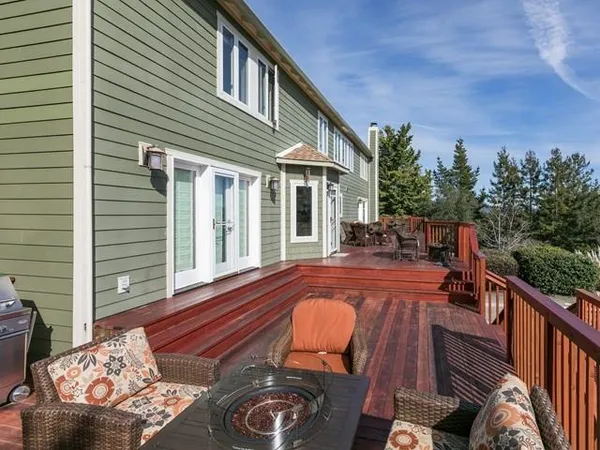 a view of a balcony with chairs and wooden floor