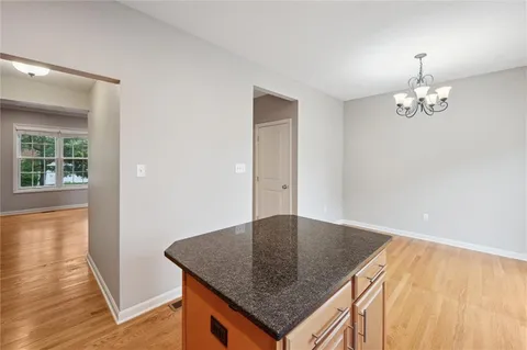 a kitchen with granite countertop white cabinets and sink