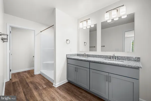 a bathroom with a granite countertop double vanity sink and mirror