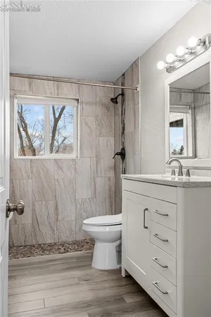 a bathroom with a granite countertop sink a toilet and a mirror