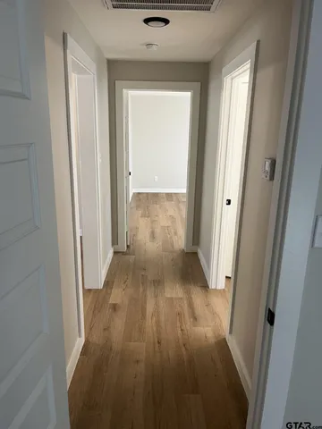 a view of a hallway with wooden floor