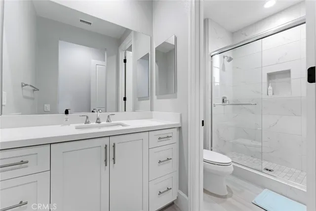 a bathroom with a double vanity sink toilet and shower