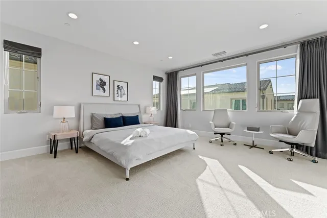 a bedroom with a bed and large windows