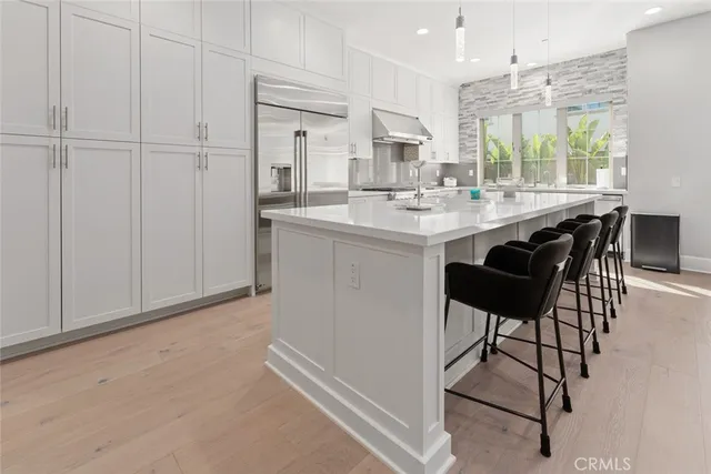 a kitchen with stainless steel appliances granite countertop a sink and a refrigerator