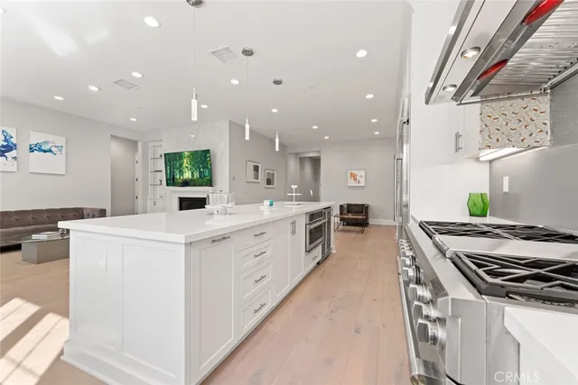 a large kitchen with stainless steel appliances a sink a counter top space and cabinets
