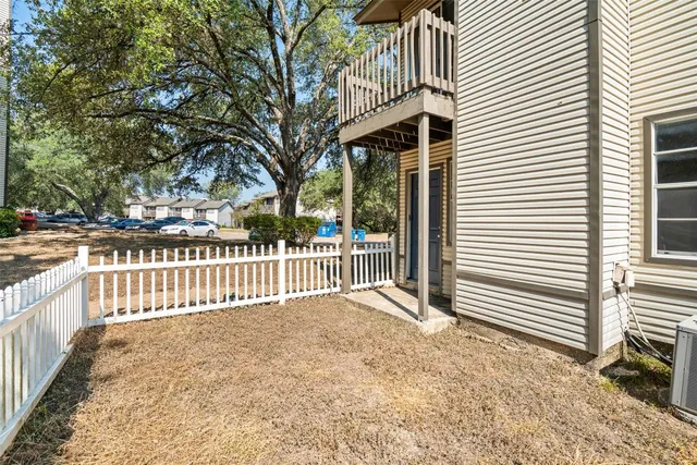 a view of a house with a fence and a tree