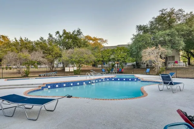 a view of a swimming pool with outdoor seating and plants