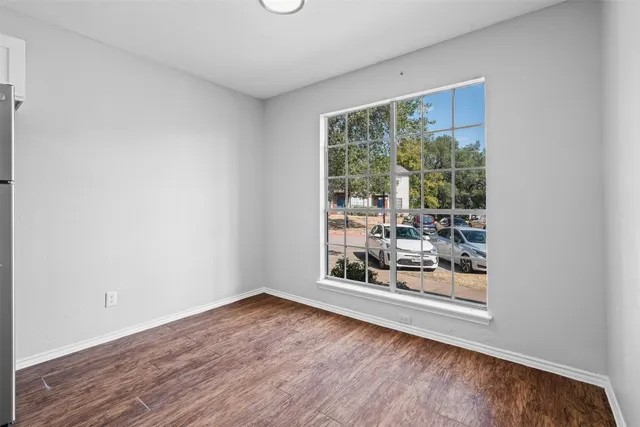 a view of a room with wooden floor and a window