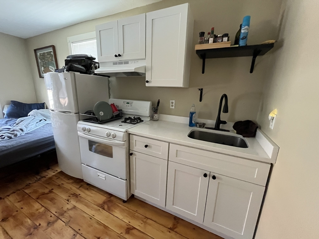 65 Main Street Hudson, MA 01749 - Photo 7 of 20 a kitchen with stainless steel appliances a sink a stove and cabinets
