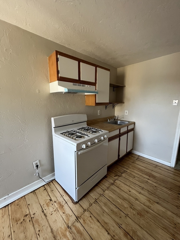 65 Main Street Hudson, MA 01749 - Photo 8 of 20 a view of kitchen with stove and wooden floor