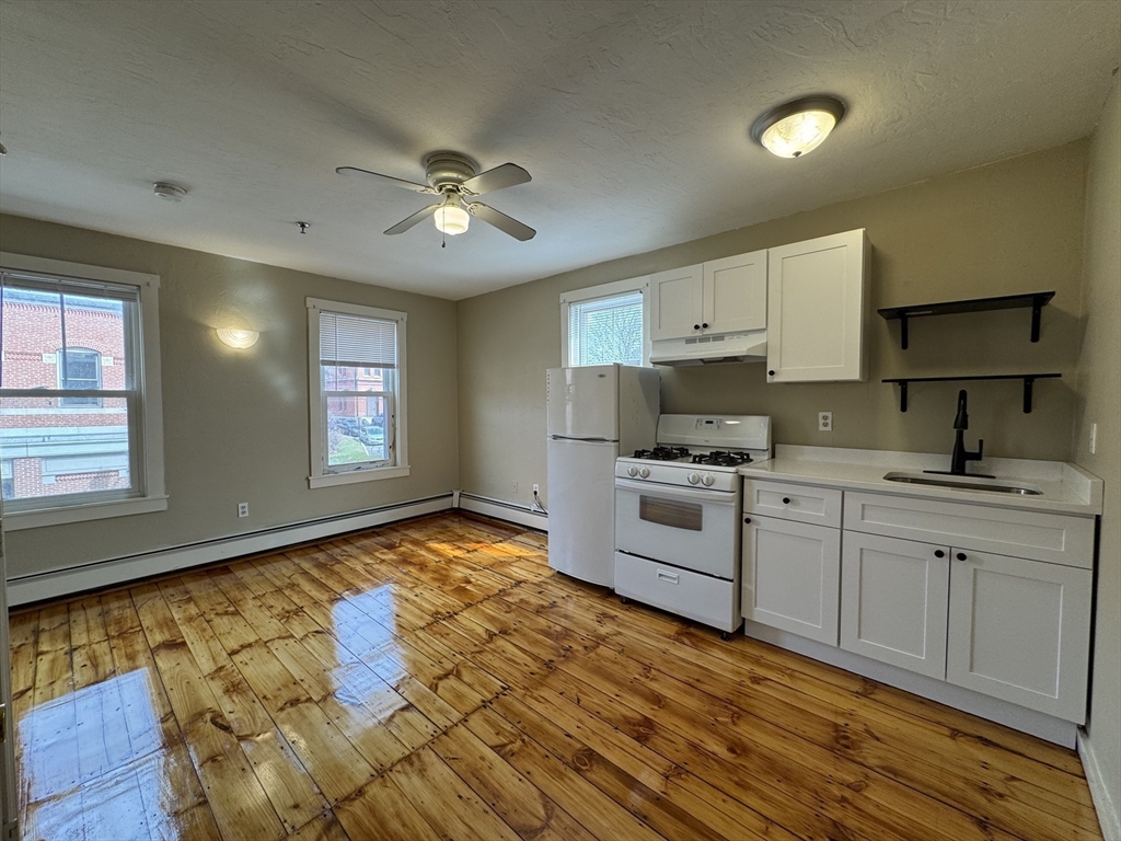 65 Main Street Hudson, MA 01749 - Photo 9 of 20 a kitchen with stainless steel appliances granite countertop a sink cabinets and wooden floor