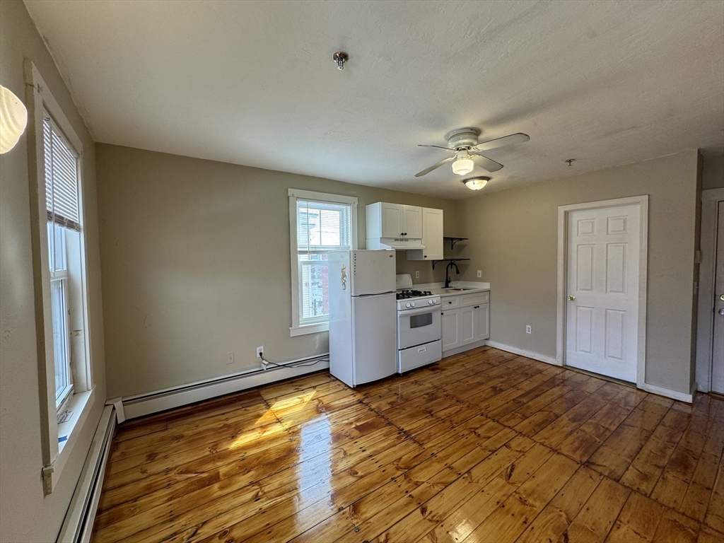 65 Main Street Hudson, MA 01749 - Photo 10 of 20 a kitchen with a stove a refrigerator and a sink
