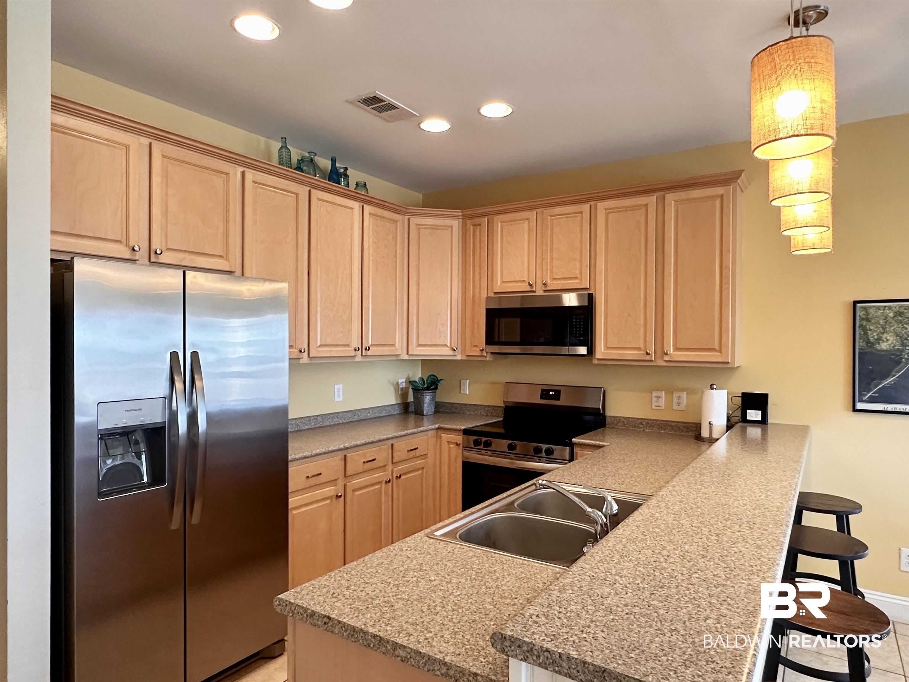 1472 Sandy Lane, Unit A Gulf Shores, AL 36542 - Photo 26 of 44 Kitchen featuring sink, appliances with stainless steel finishes, hanging light fixtures, a kitchen bar, and kitchen peninsula