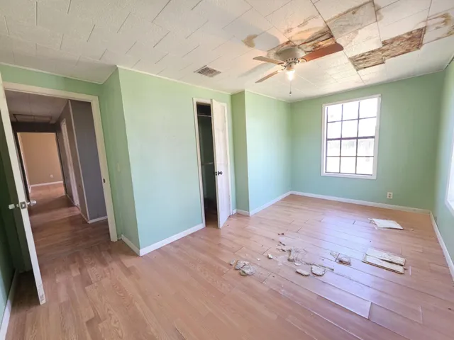 a view of empty room with window and wooden floor