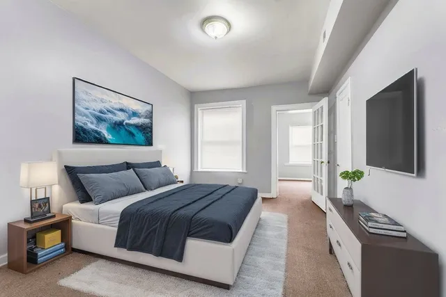 a spacious bedroom with a bed and a window