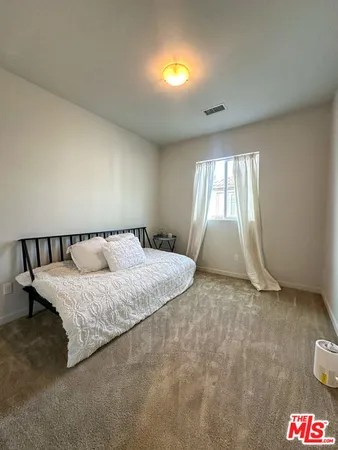 a spacious bedroom with a bed and a window