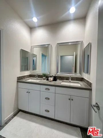 a bathroom with double sink and a mirror