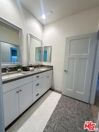 a spacious bathroom with a double vanity sink and a mirror