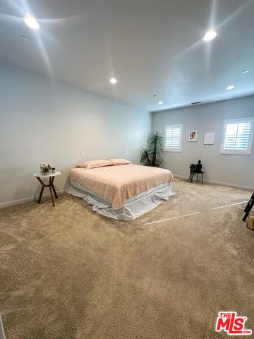 a spacious bedroom with a bed and a lamp