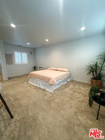 a spacious bedroom with a bed and a potted plant