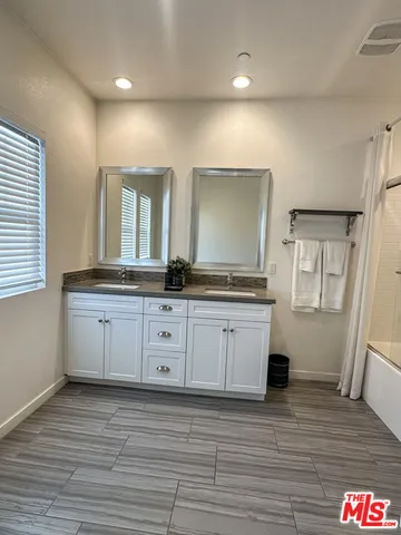a spacious bathroom with a granite countertop sink and a mirror