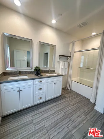a spacious bathroom with a granite countertop sink a mirror and a shower