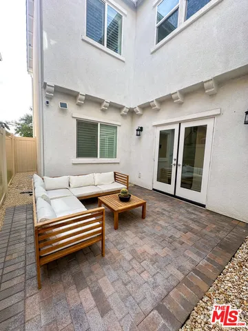 a backyard of a house with barbeque oven and glass door
