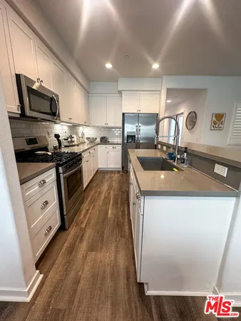 a kitchen with stainless steel appliances granite countertop a sink stove microwave and cabinets