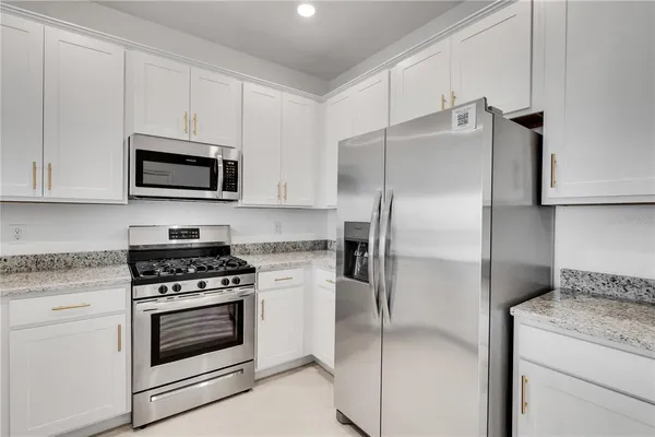 a kitchen with cabinets stainless steel appliances and a counter space