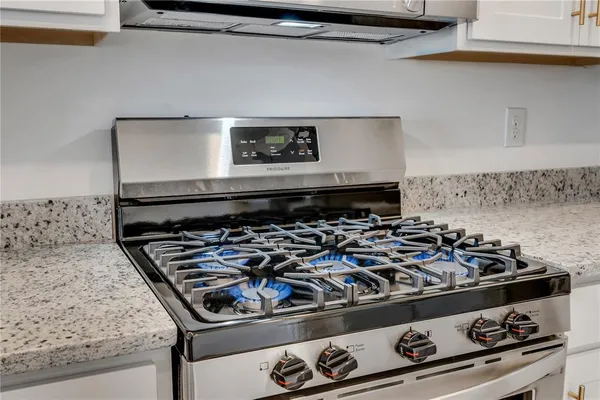 a stove top oven sitting inside of a kitchen
