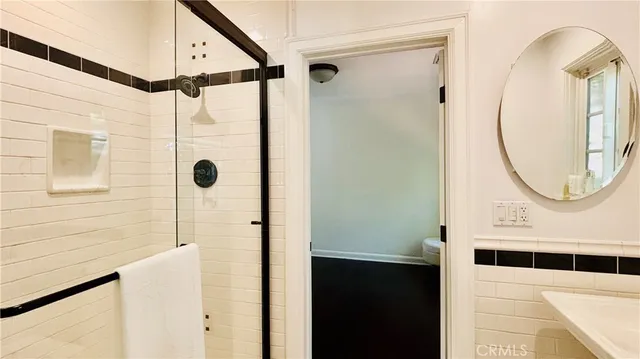 a bathroom with a glass door shower and a sink