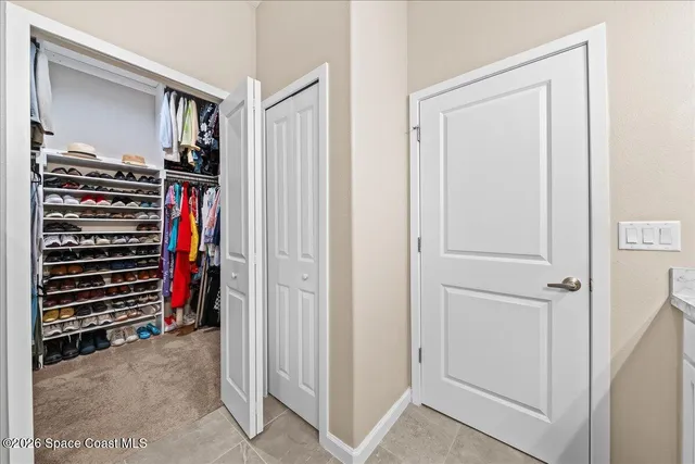 a view of a hallway with closet and furniture