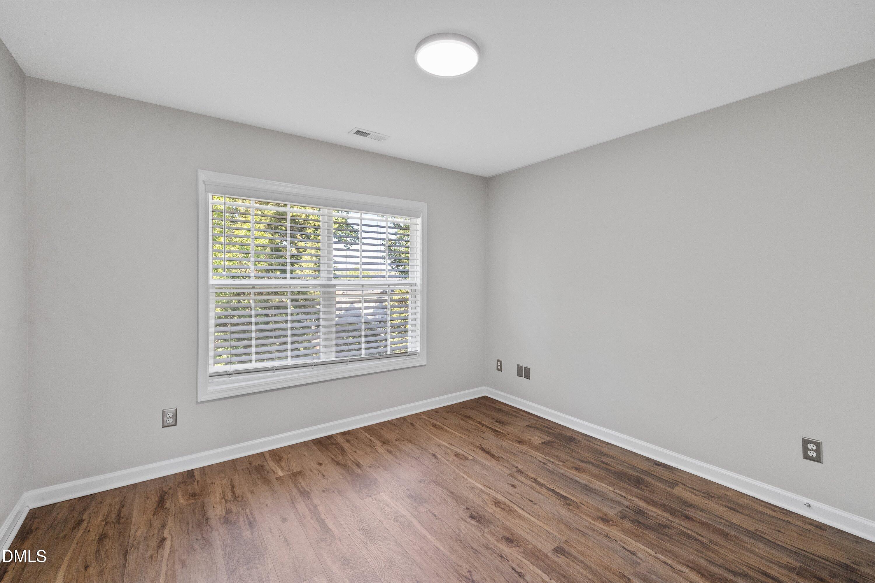 3717 Windmeade Road Wake Forest, NC 27587 - Photo 44 of 51 an empty room with wooden floor and windows
