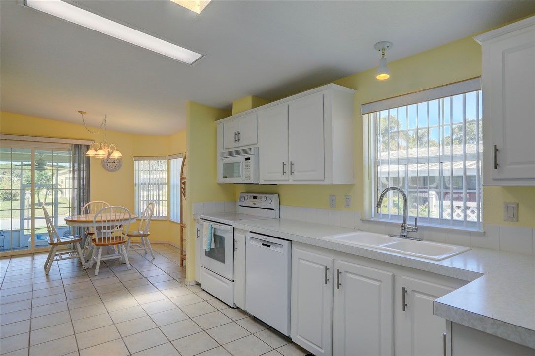 823 Tamarind Circle Sebastian, FL 32976 - Photo 8 of 33 a kitchen with a sink cabinets and dining table chair