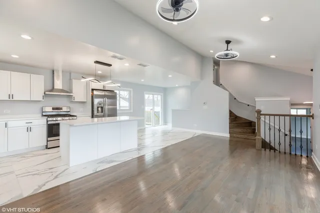 a large kitchen with cabinets wooden floor and stainless steel appliances