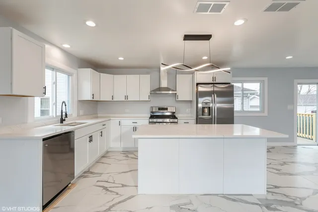 a kitchen with stainless steel appliances granite countertop a stove top oven a sink a counter top space and cabinets