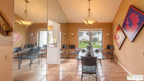 a kitchen with granite countertop a stove a sink and a white cabinets next to a window